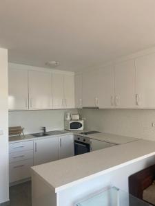 a kitchen with white cabinets and a counter top at Beachfront, 2 Bed with Sea Views in Elenite