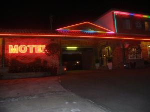 una señal de motel en el lateral de un edificio por la noche en Mt Kuring-Gai Motel en Mount Kuring-Gai