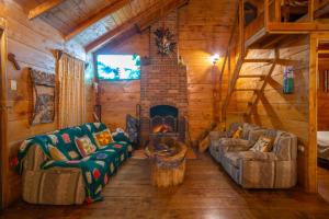 Tres de JunioCabaña de montaña La Magnolia, Cerro de la Muerte De La Cañuela Cloud Forest的小木屋内的客厅配有沙发和壁炉