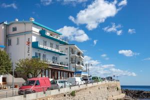 a building on the beach with cars parked in front at La casa del pescatore in Cala Gonone +41 photos