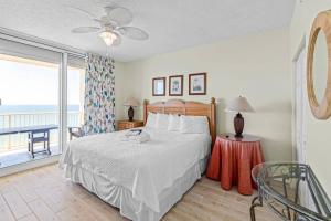a bedroom with a bed and a balcony at Beach Club D-1201 in Gulf Shores