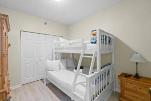 a white bunk bed in a room with a ladder at Beach Club D-1201 in Gulf Shores