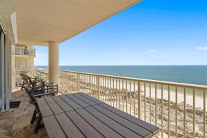 a porch with a wooden table and chairs on the beach at Beach Club D-1201 in Gulf Shores +41 photos