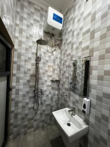 a bathroom with a white sink and a shower at Hadraj Clocktower Studio Apt in Arusha