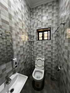 a bathroom with a toilet and a sink at Hadraj Clocktower Studio Apt in Arusha
