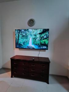 a flat screen tv sitting on top of a dresser at Sea View Studio 4 Royal Breeze Breezeسي ويو ستوديو رويال بريز in Ras al Khaimah