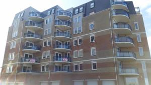 ein Gebäude mit Balkon auf der Seite in der Unterkunft Atlantis Appartement in Egmond aan Zee