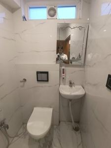 NarendranagarHotel Mount view的带马桶和水槽的白色浴室