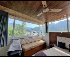 NarendranagarHotel Mount view的卧室设有大窗户、一张床和一把椅子