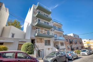 a tall building with cars parked in front of it at Unique two bedroom apt with huge outdoor area and close to entertainment in Is-Swieqi