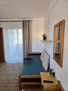 a small bedroom with a bed and a table at Philoxenia Beach Apartments Stavros in Stavros