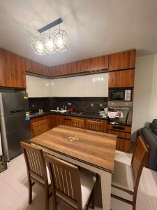 a kitchen with a wooden table and a dining room at Marassi 2 bedrooms in El Alamein