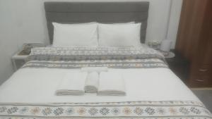 Un dormitorio con una cama con dos pantuflas encima. en Paradise Bridge, en Xanthi