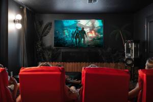 a group of people sitting in chairs watching a movie at Luxury 9BR Gem- Heated Pool, Theater & Theme Rooms in Kissimmee