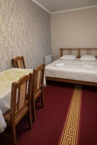 two beds in a room with two chairs and two beds sidx sidx sidx at Lovely family, Spacious room, City Center apartmen in Sheki