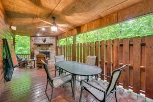 Un patio con mesa y sillas y una chimenea. en Private Hot Tub and Deck Woodsy Broken Bow Retreat, en Broken Bow 18 fotos más