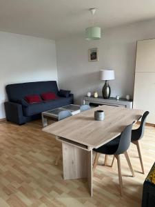 a living room with a wooden table and a couch at Studio cabine près de la plage in Le Lavandou