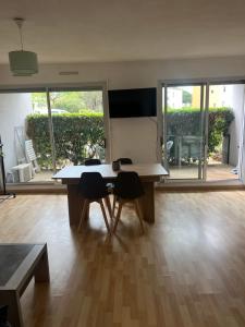 a room with a table with two chairs and a large window at Studio cabine près de la plage in Le Lavandou