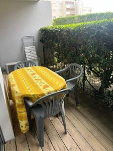 a table with a yellow blanket on top of it at Studio cabine près de la plage in Le Lavandou