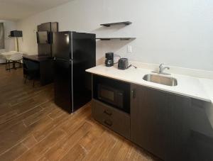 a kitchen with a sink and a black refrigerator at Studio 6 Suites Hurricane, WV in Hurricane
