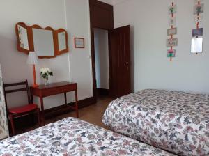 Un dormitorio con dos camas y una mesa y un espejo. en António Augusto Apartment, en Coímbra