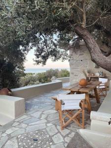 a patio with a table and chairs under a tree at Agreli House in Lichnaftia