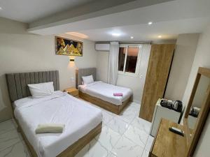 pokój hotelowy z dwoma łóżkami i oknem w obiekcie Solar Boat Pyramids View Hotel w Kairze
