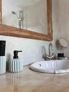 a bathroom sink with a soap dispenser and a mirror at Agreli House in Lichnaftia +49 photos
