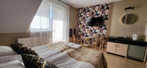a bedroom with a bed and a table in a room at Villa Rekin in Grzybowo