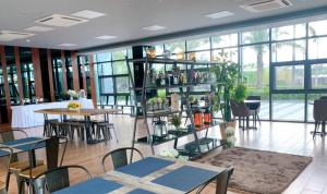 a large room with tables and chairs and windows at Loft and Luxe 1BR Condo in Clark in Fort Stotsenburg