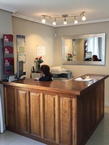 a woman is sitting at a counter in a store at Apartamentos Costa Noja in Noja +37 photos
