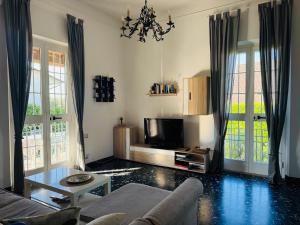 a living room with a couch and a tv at Versilia Apartment with Garden in Montignoso