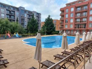 a pool with chairs and umbrellas next to some buildings at Rainbow 2 studio 7 in Sunny Beach
