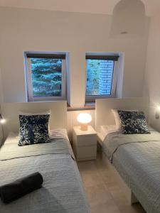 zwei Betten in einem Zimmer mit zwei Fenstern in der Unterkunft Wake Villa in Brwinów