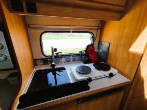a small kitchen with a stove and a window at Ella's Camper in Fontinha