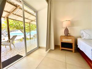 a bedroom with a bed and a door to a patio at Hotel Carey Beach Baru in Barú