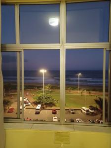 a window with a view of a parking lot at Frontline Holiday apartment in Durban