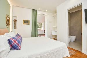 een slaapkamer met een wit bed en een badkamer bij Villa Emma in Palermo +60 foto's