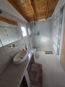 a white bathroom with a sink and a window at Lake View Loft 5 in Mursi