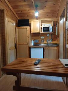 eine Küche mit einem Holztisch in einer Hütte in der Unterkunft Camping Las Cavenes in El Cabaco