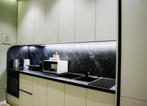 a kitchen with a sink and a microwave at Elite Guesthouse in Tirana +47 photos