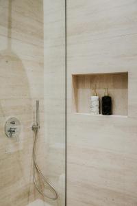 a shower with a glass door in a bathroom at Elite Guesthouse in Tirana