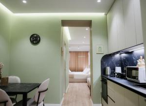 a kitchen with a table and a clock on the wall at Elite Guesthouse in Tirana