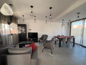 a living room with a couch and a table and chairs at Casa con piscina y parking en Roda de Berà in Roda de Bará