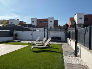 a patio with chairs and grass on a roof at Casa con piscina y parking en Roda de Berà in Roda de Bará