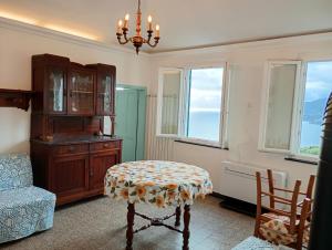 a room with a table and a chair and windows at Golfo Paradiso in Camogli +6 photos