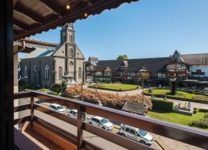 a view from a balcony of a church with cars parked in front at Locar-in Gramado - Lez Lez a 30 m da Rua Coberta in Gramado