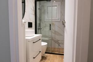 a bathroom with a toilet and a glass shower at Elegant Suite - Piraeus in Piraeus +4 photos