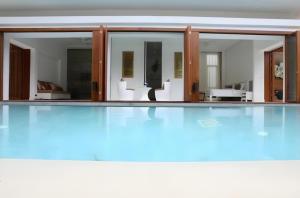 an empty swimming pool with glass doors and a swimming pool at Kehadfa One in HHQ