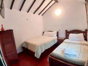 a room with two beds in a room at HOTEL El CORZO DE LA VILLA in Villa de Leyva
